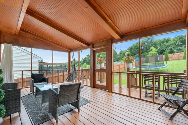 a balcony with wooden floor and outdoor seating