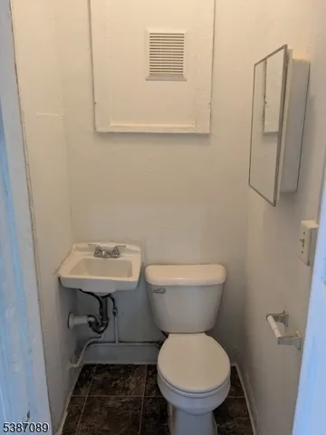 a bathroom with a toilet a sink and a mirror