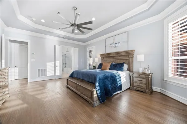 a spacious bedroom with a bed and wooden floor