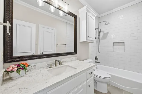 a bathroom with a granite countertop sink mirror vanity and toilet