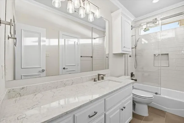 a bathroom with a granite countertop sink a toilet and shower