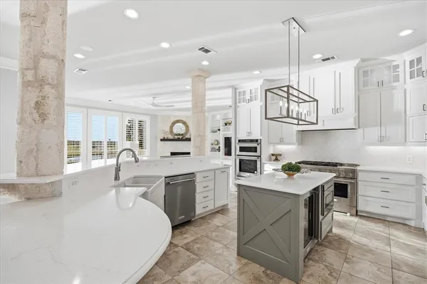 a kitchen with a sink stove cabinets and wooden floor