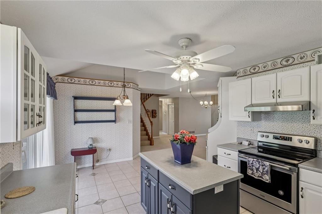 306 Country View Drive Lower Burrell, PA 15068 - Photo 16 of 50 a kitchen with stainless steel appliances granite countertop a stove a sink and a refrigerator