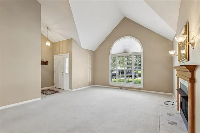 an empty room with a fireplace and windows