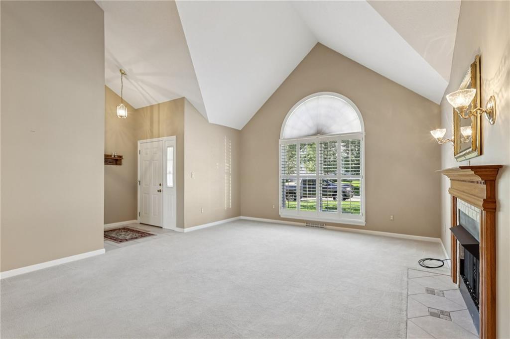 306 Country View Drive Lower Burrell, PA 15068 - Photo 5 of 50 an empty room with a fireplace and windows