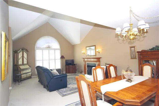 a living room with furniture a chandelier and a dining table