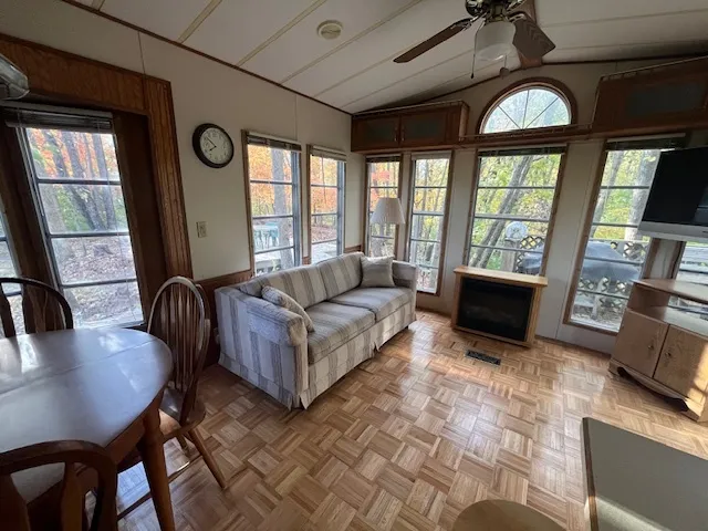 a living room with furniture a large window with kitchen view
