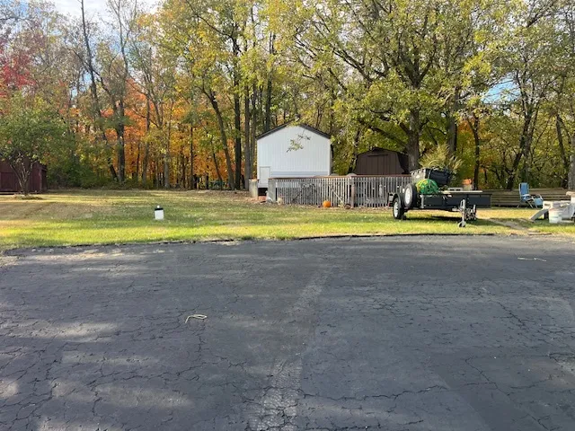 a view of backyard with wooden fence and large trees