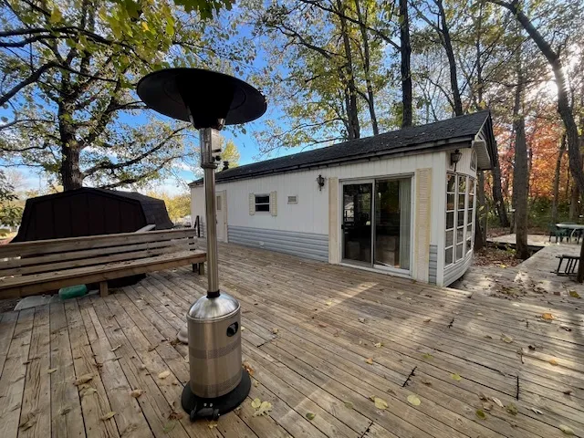 a view of a roof deck with table and chairs with wooden floor and fence