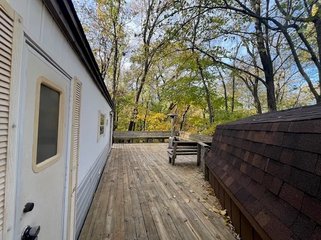 a backyard of a house with wooden floor and large trees