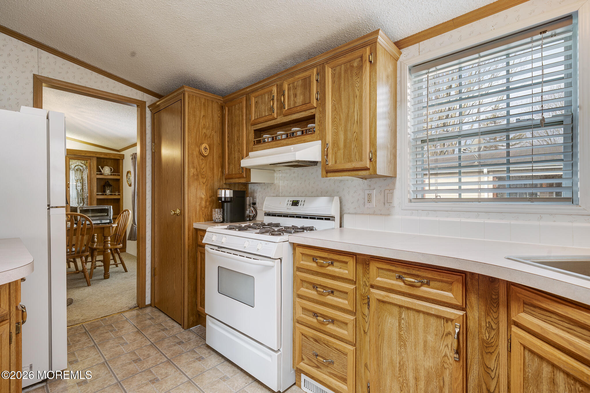 78 Village Road Morganville, NJ 07751 - Photo 8 of 25 a kitchen with white cabinets and white appliances