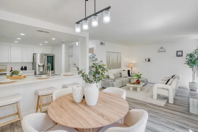 a living room with furniture kitchen view and a potted plant