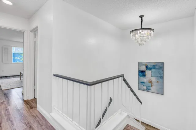 a view of a hallway with wooden floor and staircase