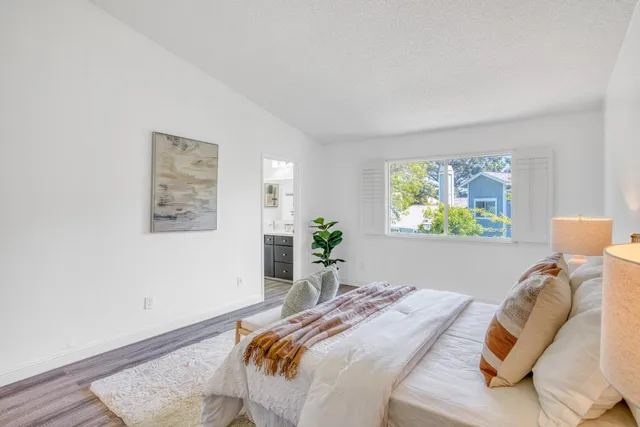 a bedroom with a bed and a painting on the wall
