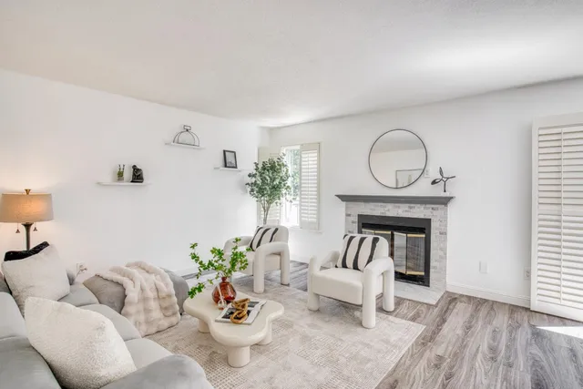 a living room with furniture a fireplace and a window