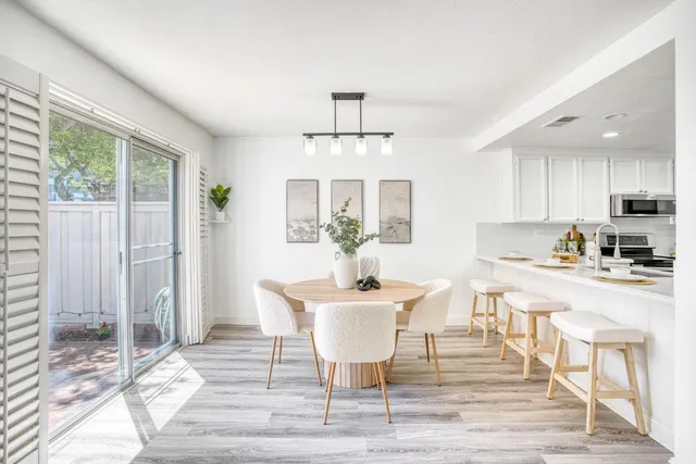 a kitchen with a dining table chairs and refrigerator