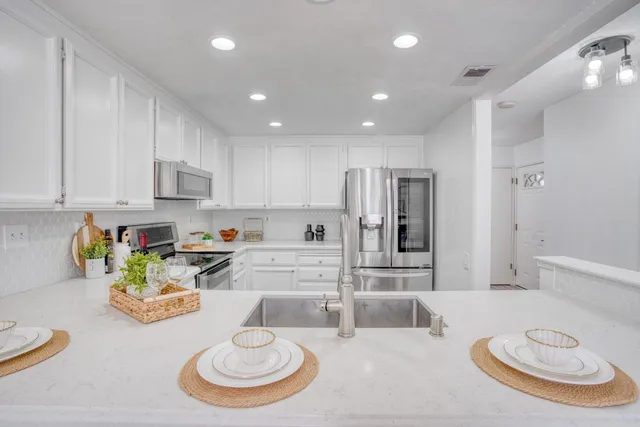 a kitchen with stainless steel appliances kitchen island granite countertop a sink and cabinets