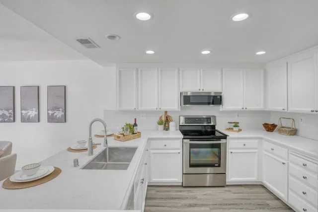 a kitchen with granite countertop a sink and white stainless steel appliances