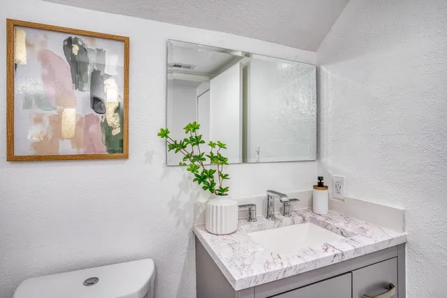 a bathroom with a granite countertop sink and a mirror
