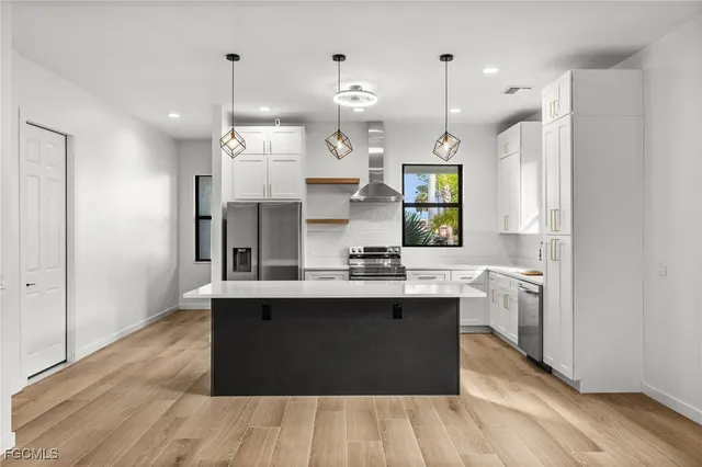 a kitchen with kitchen island a sink stainless steel appliances and cabinets