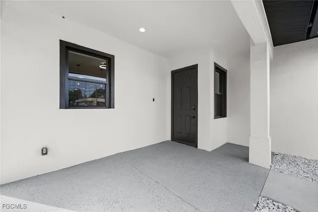 a view of an empty room with closet and a window