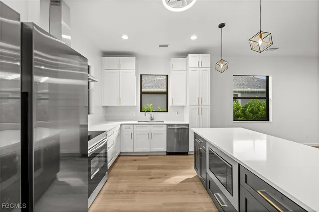 a large kitchen with stainless steel appliances kitchen island granite countertop a refrigerator a sink and a stove