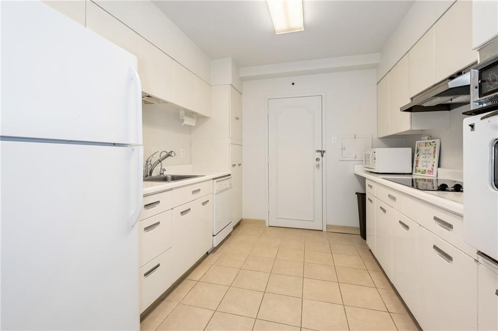 128 North Craig Street, Unit 412 Pittsburgh, PA 15213 - Photo 4 of 17 a kitchen with white cabinets and appliances