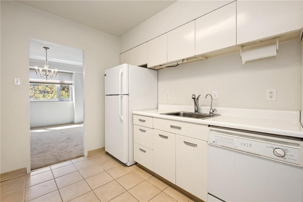 128 North Craig Street, Unit 412 Pittsburgh, PA 15213 - Photo 5 of 17 a kitchen with white cabinets and refrigerator