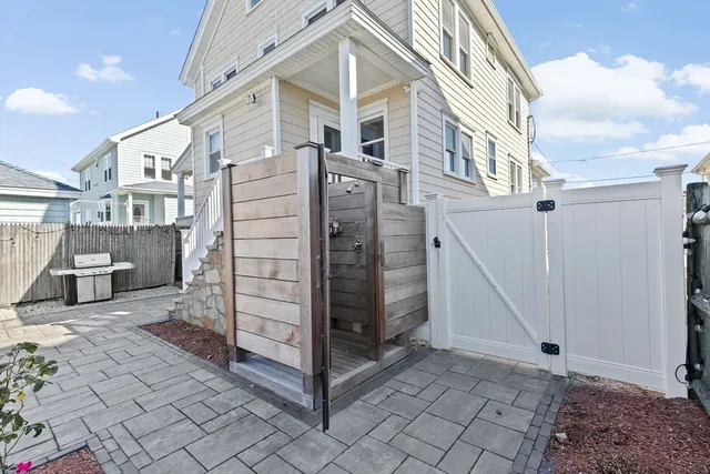 a view of a house with a small yard and wooden fence