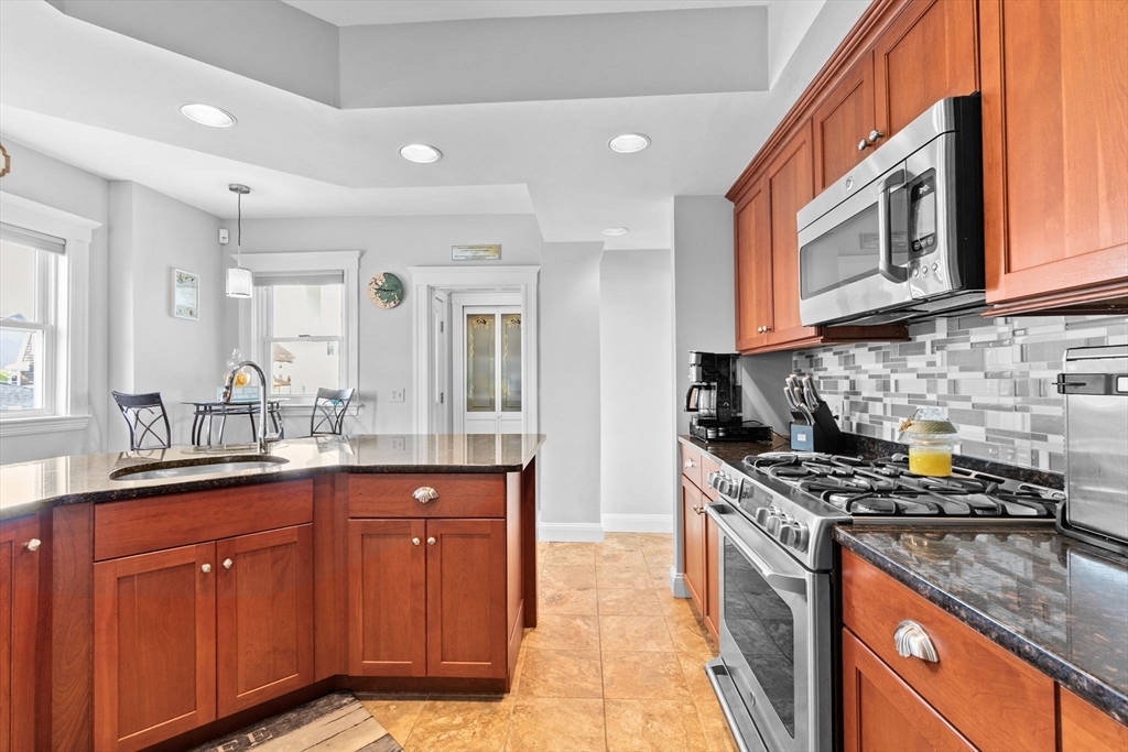 79 F Street Hull, MA 02045 - Photo 17 of 35 a kitchen with stainless steel appliances granite countertop a sink stove and cabinets