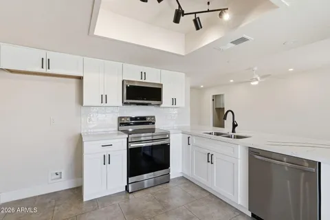 a kitchen with stainless steel appliances a sink stove and refrigerator