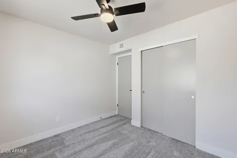 an empty room with a ceiling fan and a window