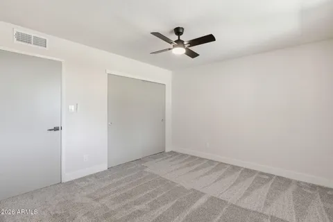 a view of a big room with wooden floor closet and fan
