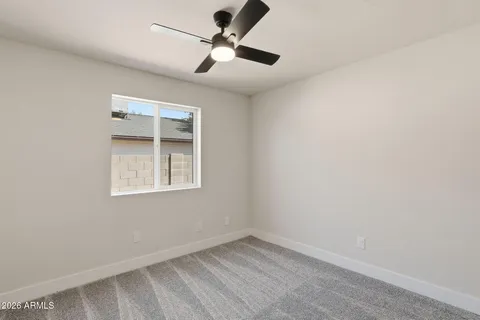 an empty room with a window and a fan