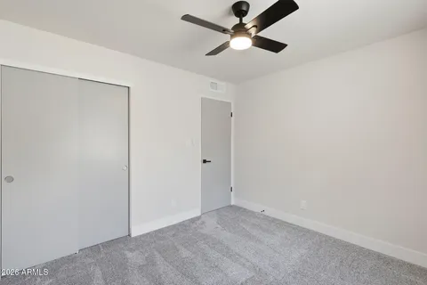 an empty room with a ceiling fan and a window