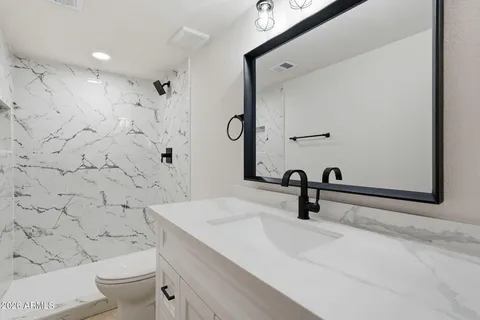 a bathroom with a sink toilet a mirror and shower