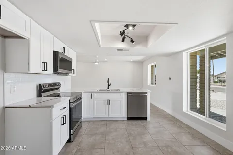 a kitchen with stainless steel appliances a sink stove and cabinets