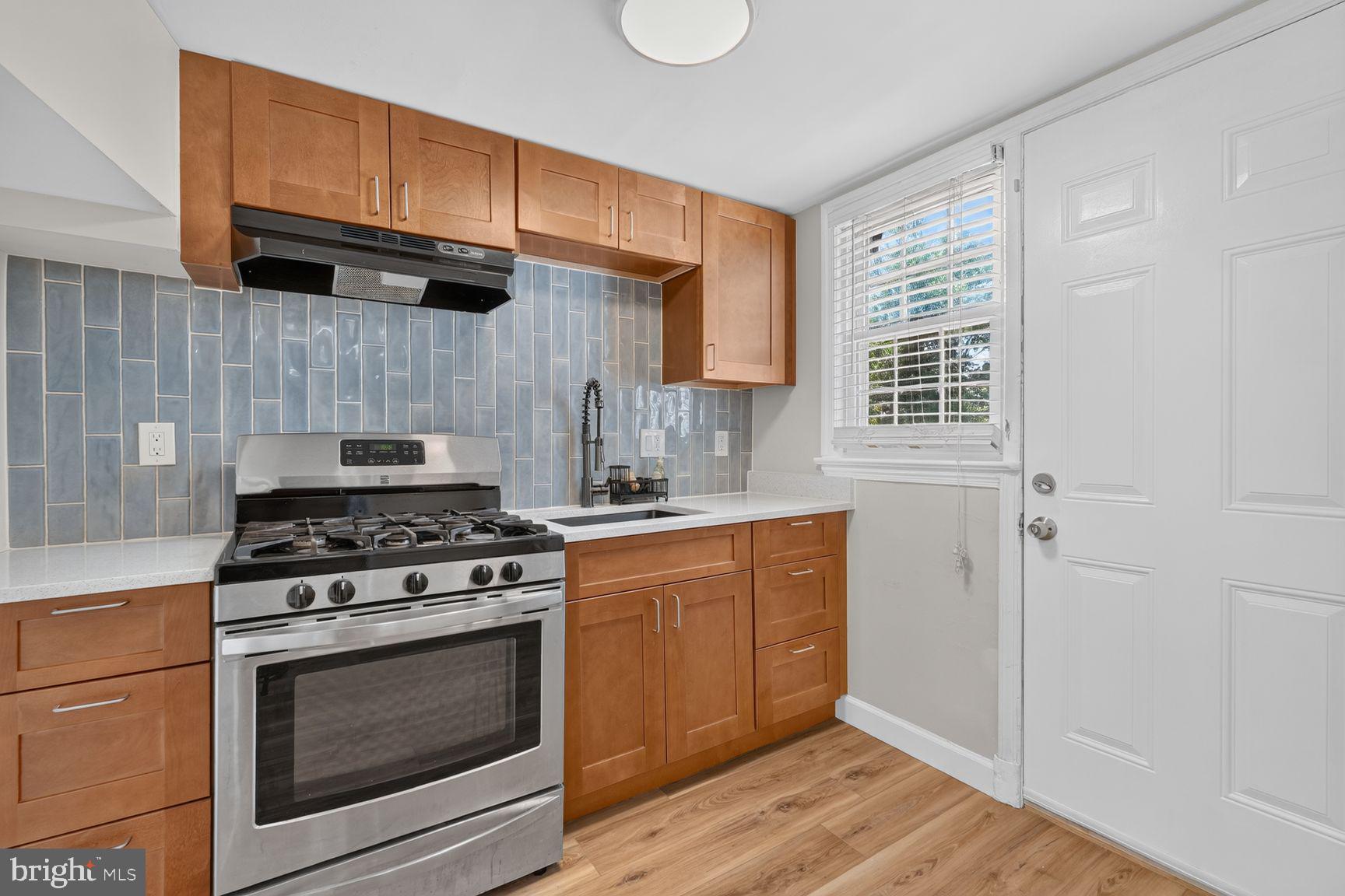 2437 Iverson Street Temple Hills, MD 20748 - Photo 7 of 15 a kitchen with granite countertop wooden cabinets stainless steel appliances and a window