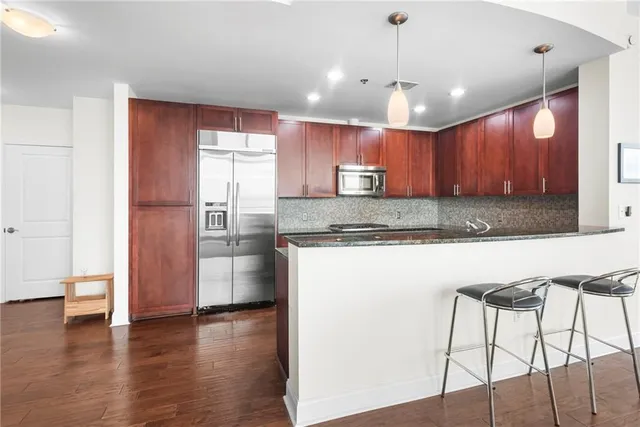a kitchen with kitchen island granite countertop wooden cabinets and a granite counter tops