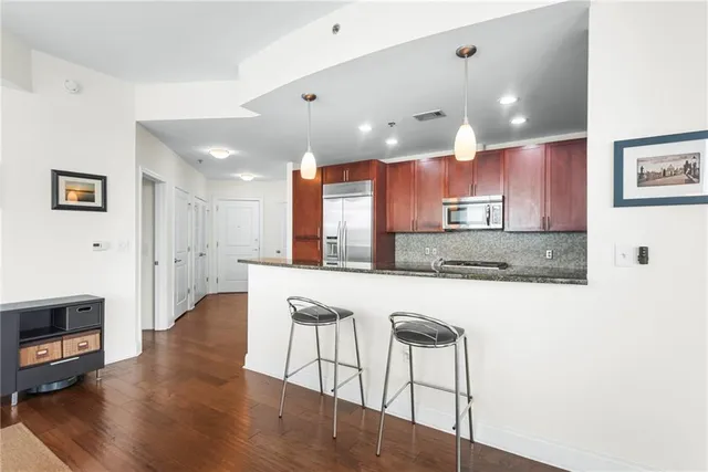 a large kitchen with kitchen island a island a sink a stove and a wooden floor