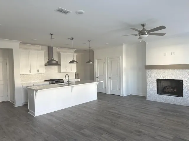 a large kitchen with cabinets wooden floor and a fireplace