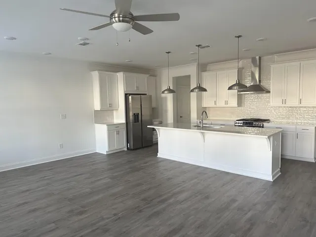 a kitchen with stainless steel appliances a refrigerator and wooden floor