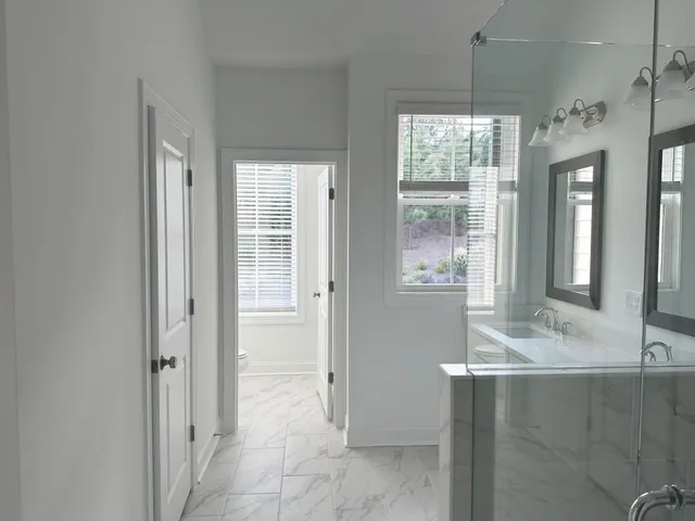 a bathroom with a sink shower and a mirror