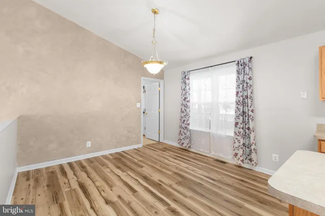 a view of a livingroom with wooden floor and a window