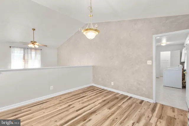 a view of a room with wooden floor and a ceiling fan