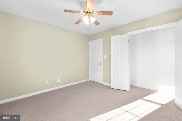 a view of a room with a ceiling fan and a window