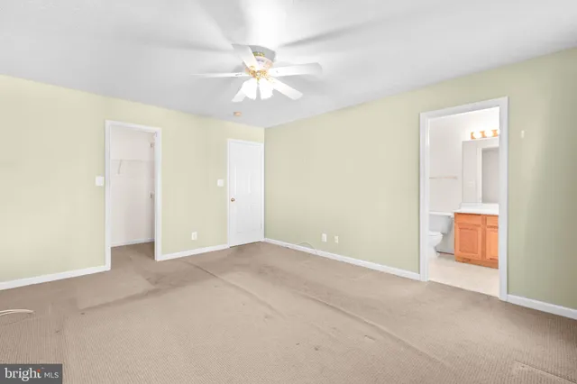 an empty room with a ceiling fan and a window
