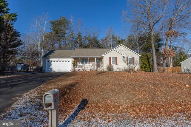 a front view of a house with yard and trees