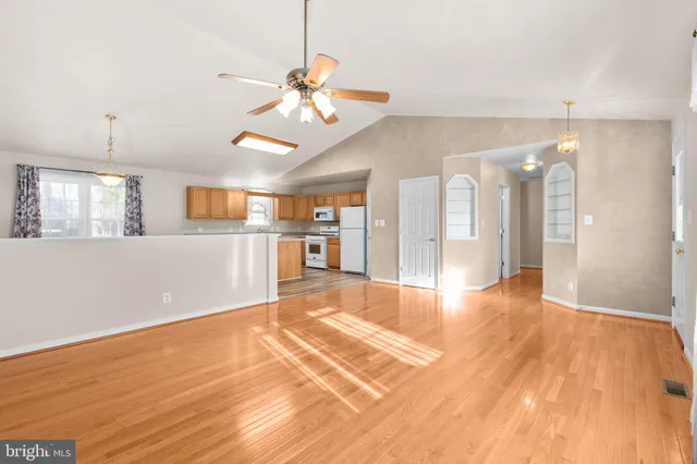 a view of an empty room and kitchen view