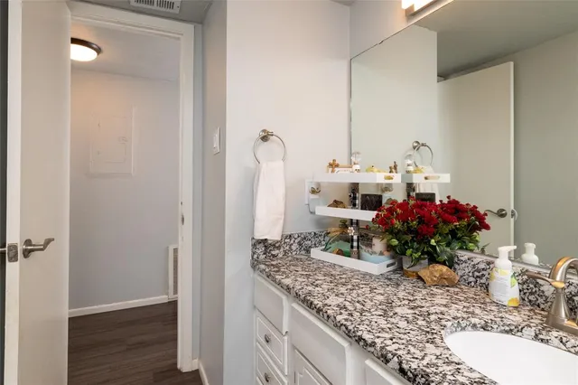a bathroom with a granite countertop sink a mirror and a shower